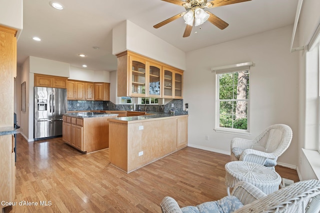 182 Sunnyside Rd, Sandpoint, ID 83864 - kitchen featuring stainless steel refrigerator with ice dispenser, a kitchen island, glass insert cabinets, tasteful backsplash, and recessed lighting