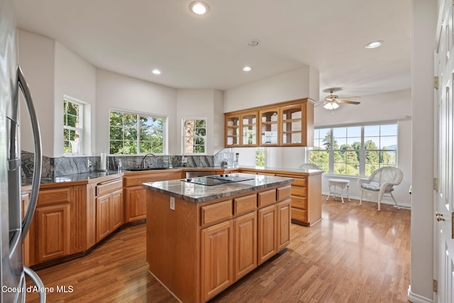 182 Sunnyside Rd, Sandpoint, ID 83864 - kitchen with black electric cooktop, recessed lighting, light wood-style floors, glass insert cabinets, and a center island