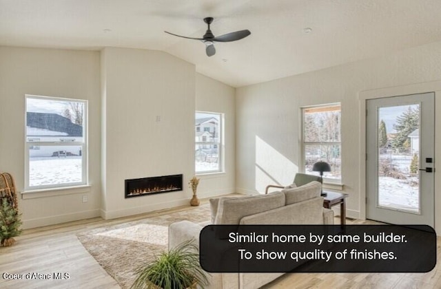 225 Jasper Loop, Ponderay, ID 83852 - living room featuring plenty of natural light, wood finished floors, vaulted ceiling, ceiling fan, and a fireplace