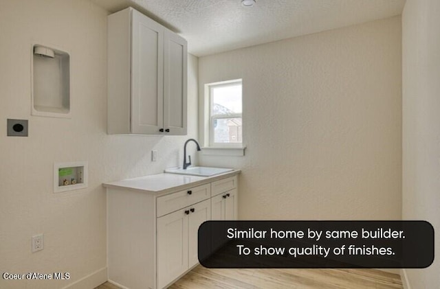 225 Jasper Loop, Ponderay, ID 83852 - laundry room featuring hookup for a washing machine, electric dryer hookup, cabinet space, light wood-style floors, and a textured ceiling