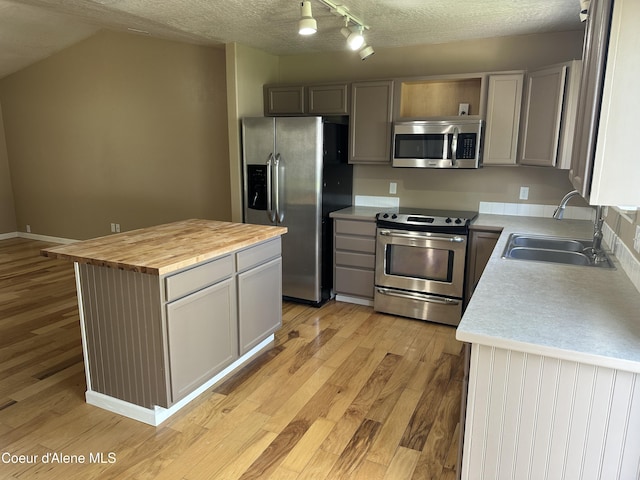 3619 W Manning Loop, Coeur Dalene, ID 83815 - kitchen featuring appliances with stainless steel finishes, wooden counters, light wood finished floors, a kitchen island, and a textured ceiling