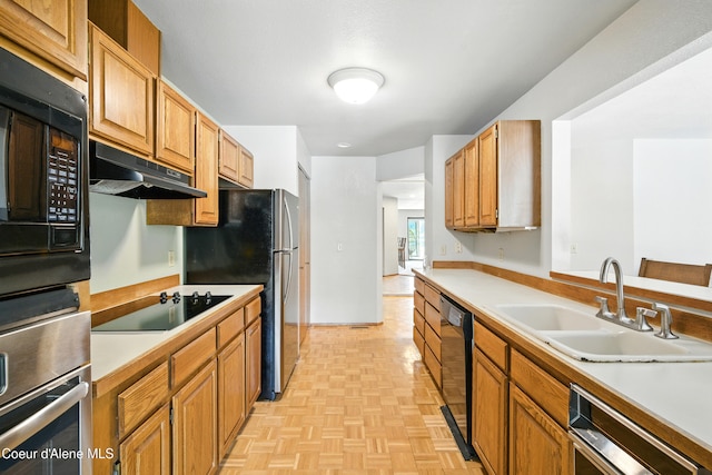 204 E 1st Ave E # 4, Post Falls, ID 83854 - kitchen featuring black appliances, under cabinet range hood, light countertops, and brown cabinets