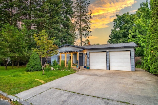 3212 N 7th St, Coeur Dalene, ID 83815 - view of front of house with a lawn, a garage, concrete driveway, and a chimney