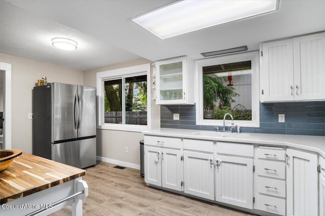 3212 N 7th St, Coeur Dalene, ID 83815 - kitchen with freestanding refrigerator, white cabinets, tasteful backsplash, and light wood-type flooring