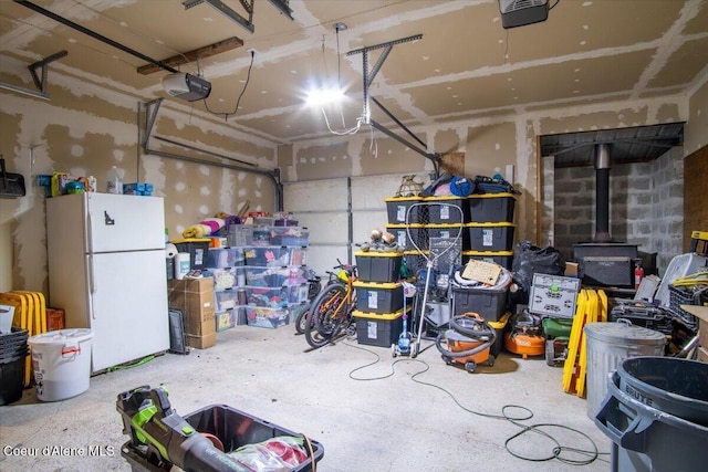 3212 N 7th St, Coeur Dalene, ID 83815 - garage featuring freestanding refrigerator, a wood stove, and a garage door opener
