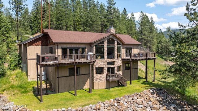 602 Country Club Ln, Pinehurst, ID 83850 - back of house featuring stone siding, a chimney, a wooden deck, and a yard