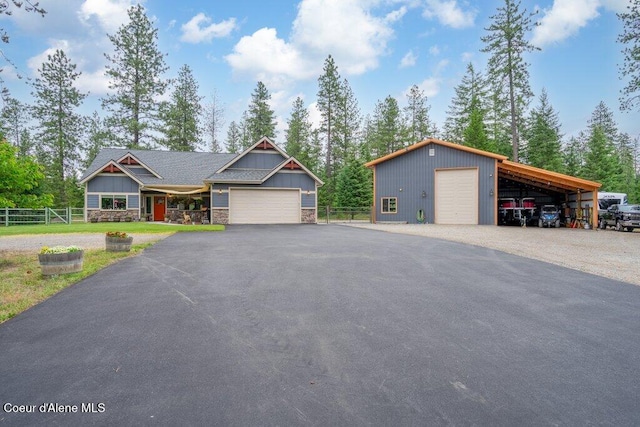 695 W Keva Ln, Athol, ID 83801 - view of front facade with a detached garage, stone siding, asphalt driveway, board and batten siding, and an outdoor structure