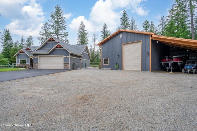 695 W Keva Ln, Athol, ID 83801 - view of front of home featuring asphalt driveway, a detached garage, an outdoor structure, board and batten siding, and stone siding
