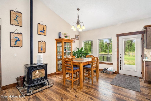 695 W Keva Ln, Athol, ID 83801 - dining space with a chandelier, healthy amount of natural light, dark wood-type flooring, a wood stove, and lofted ceiling