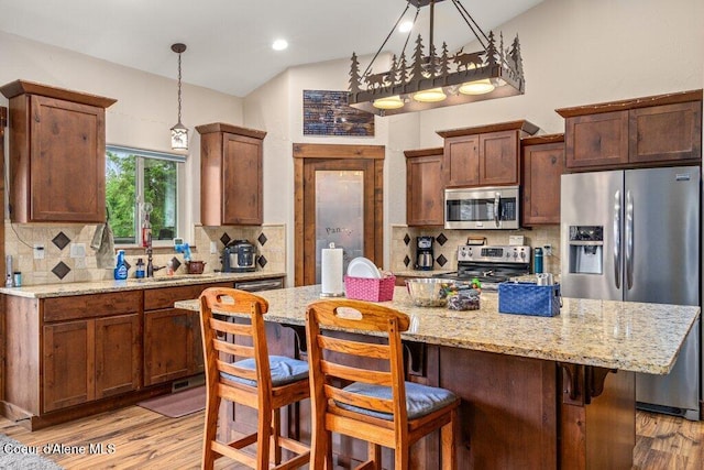 695 W Keva Ln, Athol, ID 83801 - kitchen with stainless steel appliances, light wood-style floors, backsplash, light stone countertops, and recessed lighting