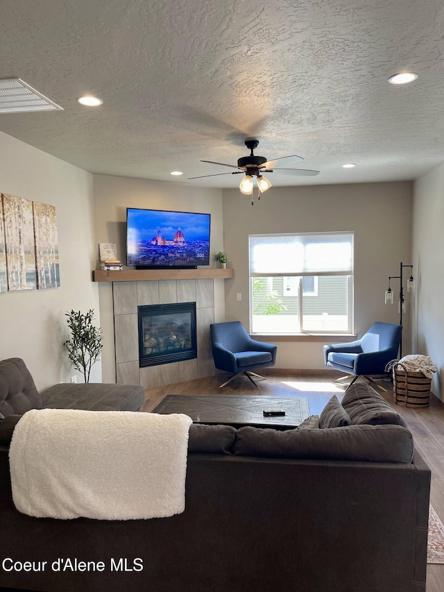 4263 N Donovan Ln, Post Falls, ID 83854 - living room with wood finished floors, a textured ceiling, a fireplace, ceiling fan, and recessed lighting