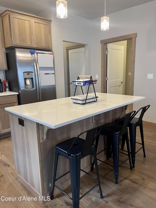 4263 N Donovan Ln, Post Falls, ID 83854 - kitchen featuring stainless steel fridge, wood finished floors, a kitchen bar, and light countertops