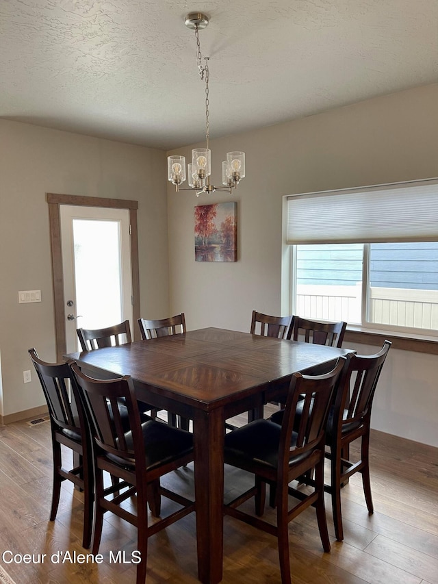4263 N Donovan Ln, Post Falls, ID 83854 - dining area with a chandelier, light wood finished floors, and a textured ceiling