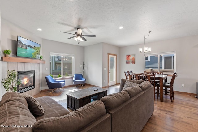 4263 N Donovan Ln, Post Falls, ID 83854 - living room with a chandelier, a tile fireplace, recessed lighting, wood finished floors, and ceiling fan