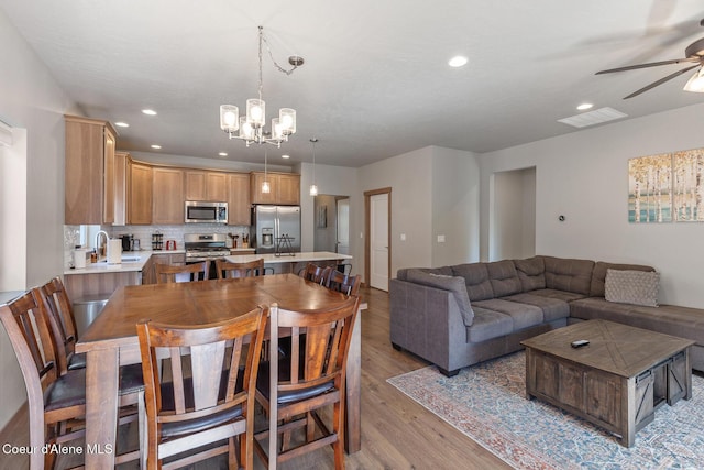 4263 N Donovan Ln, Post Falls, ID 83854 - dining space with a ceiling fan, light wood-style flooring, a chandelier, and recessed lighting