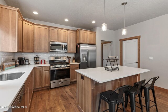 4263 N Donovan Ln, Post Falls, ID 83854 - kitchen with stainless steel appliances, dark wood finished floors, a breakfast bar area, tasteful backsplash, and recessed lighting