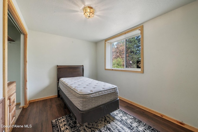 9067 W Coeur D Alene Dr, Spirit Lake, ID 83869 - bedroom featuring dark wood-type flooring and baseboards