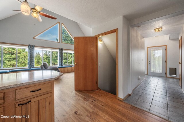 9067 W Coeur D Alene Dr, Spirit Lake, ID 83869 - kitchen with vaulted ceiling, light wood-style floors, a textured ceiling, ceiling fan, and brown cabinetry