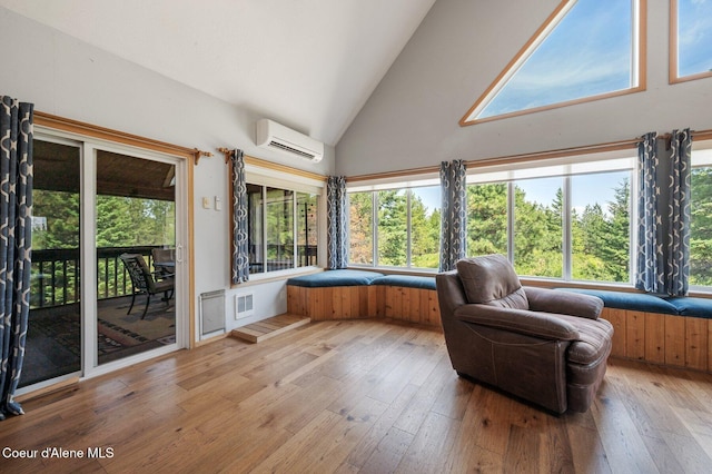 9067 W Coeur D Alene Dr, Spirit Lake, ID 83869 - sunroom / solarium with a wall mounted AC, wood-type flooring, high vaulted ceiling, and a wooden deck