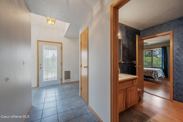 9067 W Coeur D Alene Dr, Spirit Lake, ID 83869 - hall with a textured ceiling, a chandelier, a textured wall, and tile patterned floors