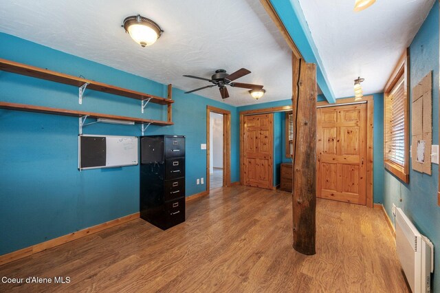9067 W Coeur D Alene Dr, Spirit Lake, ID 83869 - unfurnished bedroom featuring wood finished floors and radiator