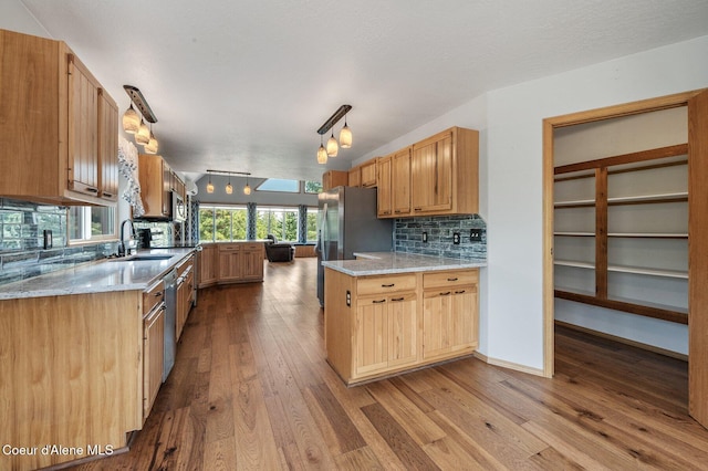9067 W Coeur D Alene Dr, Spirit Lake, ID 83869 - kitchen featuring tasteful backsplash, dark wood-style flooring, light stone counters, appliances with stainless steel finishes, and pendant lighting