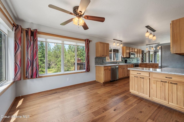 9067 W Coeur D Alene Dr, Spirit Lake, ID 83869 - kitchen featuring stainless steel appliances, light countertops, backsplash, and wood finished floors