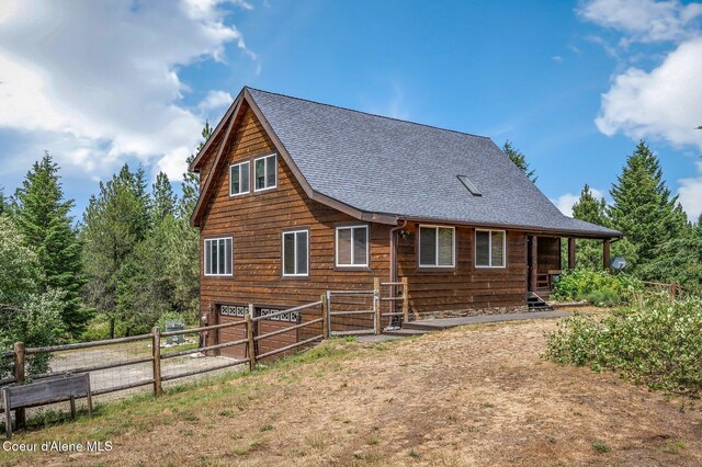 9067 W Coeur D Alene Dr, Spirit Lake, ID 83869 - view of side of home featuring a shingled roof and a garage
