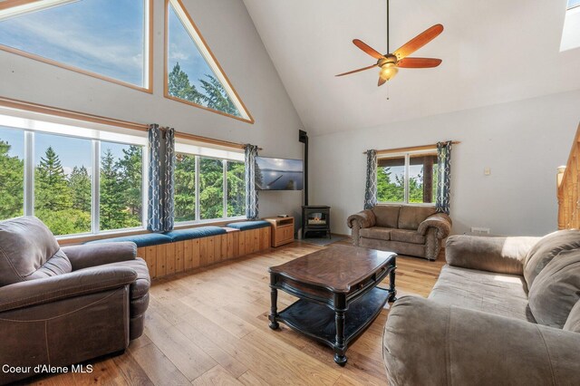 9067 W Coeur D Alene Dr, Spirit Lake, ID 83869 - living room with high vaulted ceiling, a wood stove, a ceiling fan, healthy amount of natural light, and light wood-style floors