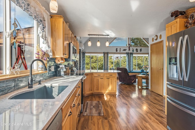 9067 W Coeur D Alene Dr, Spirit Lake, ID 83869 - kitchen featuring appliances with stainless steel finishes, a peninsula, dark wood-style floors, hanging light fixtures, and light stone counters