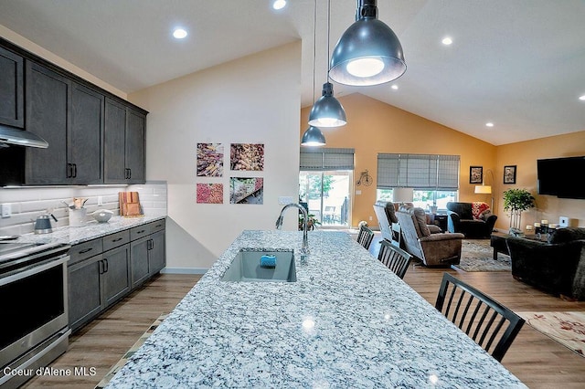 2052 W Bernard Dr, Coeur Dalene, ID 83815 - kitchen with electric range, vaulted ceiling, light stone countertops, open floor plan, and hanging light fixtures