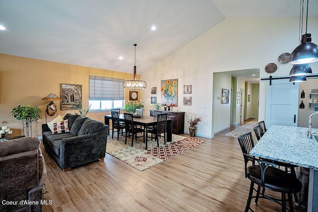 2052 W Bernard Dr, Coeur Dalene, ID 83815 - dining room with a chandelier, a barn door, light wood-style floors, high vaulted ceiling, and recessed lighting