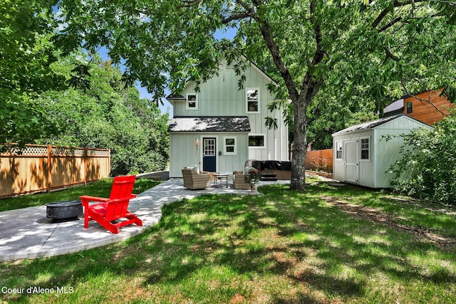 917 N Boyer Ave, Sandpoint, ID 83864 - rear view of property featuring a fire pit, a patio, board and batten siding, and a storage shed