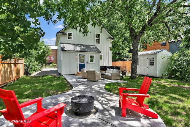 917 N Boyer Ave, Sandpoint, ID 83864 - back of house with board and batten siding, an outdoor living space with a fire pit, a patio area, a fenced backyard, and a shed