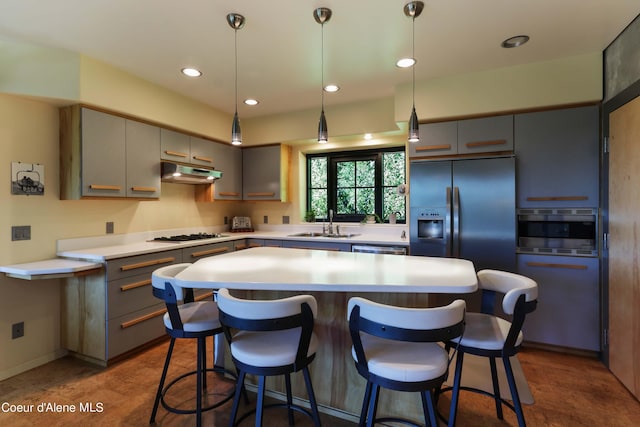677 Telemark Rd Unit 1, Sandpoint, ID 83864 - kitchen featuring stainless steel appliances, under cabinet range hood, gray cabinetry, a breakfast bar area, and a center island