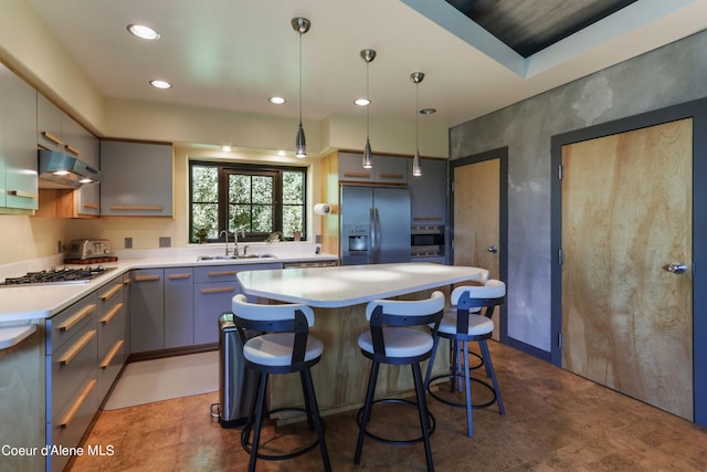 677 Telemark Rd Unit 1, Sandpoint, ID 83864 - kitchen with appliances with stainless steel finishes, under cabinet range hood, a center island, light countertops, and a kitchen bar