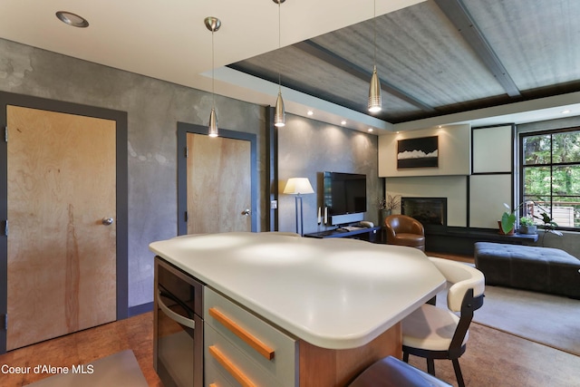 677 Telemark Rd Unit 1, Sandpoint, ID 83864 - kitchen with open floor plan, pendant lighting, a kitchen island, a glass covered fireplace, and a breakfast bar area
