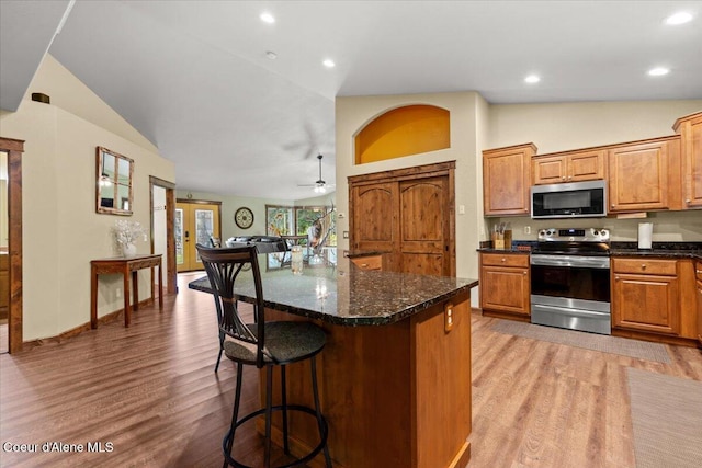 438 Berry Hl, Cocolalla, ID 83813 - kitchen featuring stainless steel appliances, light wood-type flooring, lofted ceiling, a kitchen breakfast bar, and recessed lighting