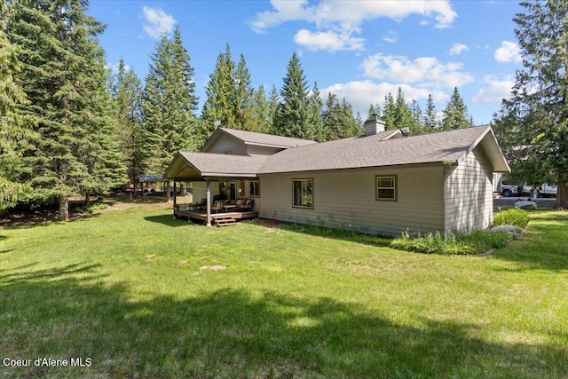 438 Berry Hl, Cocolalla, ID 83813 - back of house featuring a chimney, a yard, a wooden deck, and a shingled roof