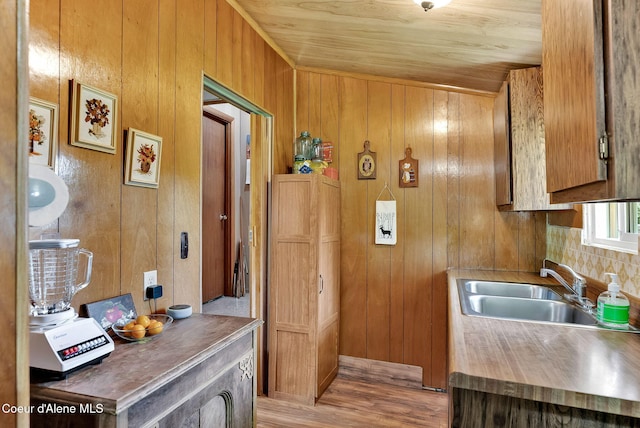 498 Lakeview Rd, Bayview, ID 83803 - kitchen with wooden walls, light wood-type flooring, and brown cabinetry