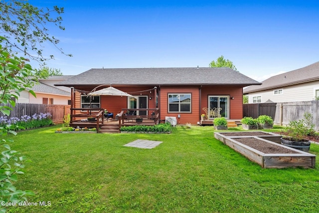 1625 Sequoia, Sandpoint, ID 83864 - rear view of property with a vegetable garden, a fenced backyard, a wooden deck, and a shingled roof