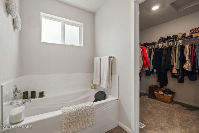 2962 N Swainson Ln, Liberty Lake, WA 99019 - bathroom featuring a bath, a spacious closet, and recessed lighting