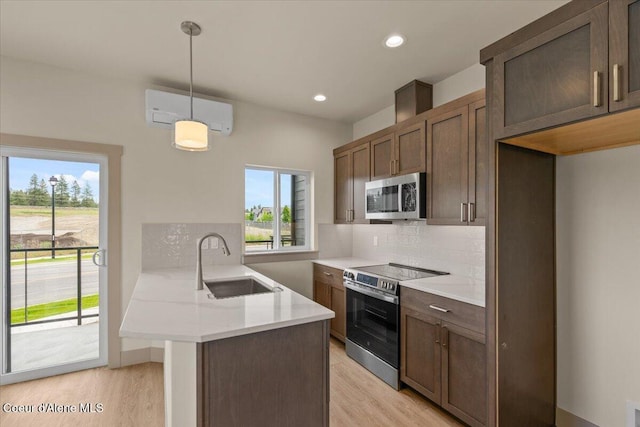 3026 Suzanne C, Coeur Dalene, ID 83815 - kitchen featuring stainless steel appliances, a wall unit AC, light wood-style flooring, a peninsula, and recessed lighting