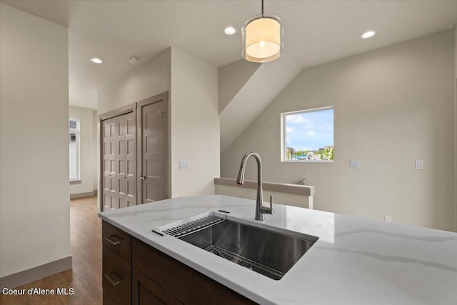 3026 Suzanne C, Coeur Dalene, ID 83815 - kitchen featuring wood finished floors, light stone countertops, pendant lighting, recessed lighting, and dark brown cabinets