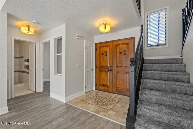 1922 E Rodkey Dr, Post Falls, ID 83854 - entryway with stairway, light wood-style flooring, and a textured ceiling