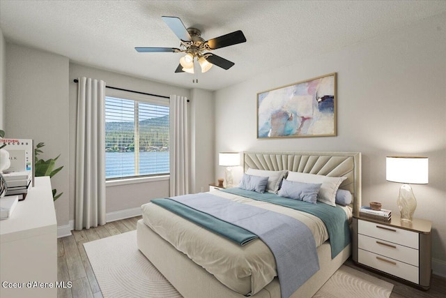 1922 E Rodkey Dr, Post Falls, ID 83854 - bedroom featuring light wood-style flooring, a textured ceiling, and a ceiling fan
