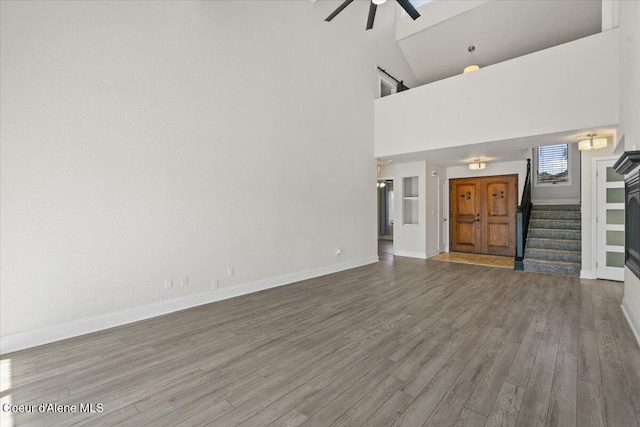 1922 E Rodkey Dr, Post Falls, ID 83854 - unfurnished living room with a ceiling fan, high vaulted ceiling, stairs, and wood finished floors