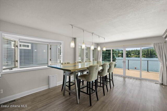 1922 E Rodkey Dr, Post Falls, ID 83854 - dining space with a textured ceiling, wood finished floors, track lighting, and a water view