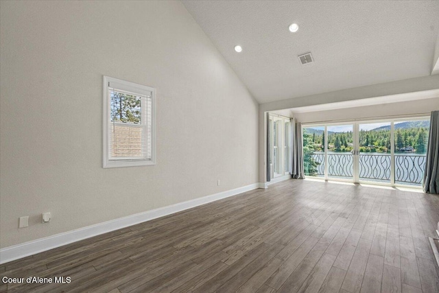 1922 E Rodkey Dr, Post Falls, ID 83854 - empty room with plenty of natural light, wood finished floors, vaulted ceiling, and recessed lighting