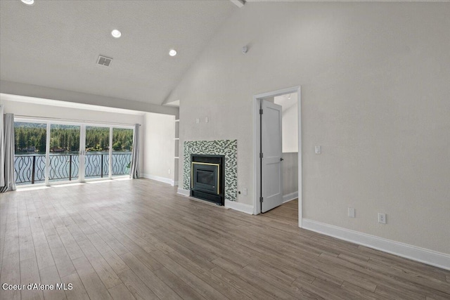 1922 E Rodkey Dr, Post Falls, ID 83854 - unfurnished living room featuring high vaulted ceiling, a fireplace, wood finished floors, and recessed lighting